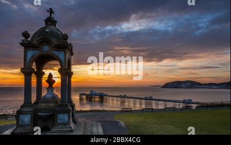 Queen Victoria Monument mit Blick auf den Llandudno Pier bei Sonnenaufgang, Badeort Llandudno, Nordwales, Großbritannien. Stockfoto