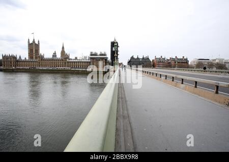 London, Großbritannien. April 2020. Tag Nine of Lockdown in London. Eine Handvoll Menschen überqueren die Westminster Bridge um 12.50 Uhr, während sie fast ohne Verkehr ist, da das Land aufgrund der COVID-19-Coronavirus-Pandemie in der Sperrstelle ist. Die Menschen dürfen nicht nach Hause gehen, außer bei minimalem Lebensmitteleinkauf, medizinischer Behandlung, Bewegung - einmal am Tag und wesentlicher Arbeit. COVID-19 Coronavirus Lockdown, London, Großbritannien, am 1. April 2020 Credit: Paul Marriott/Alamy Live News Stockfoto