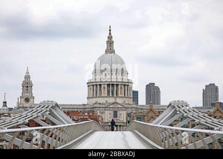 London, Großbritannien. April 2020. Tag Nine of Lockdown in London. Eine Person spaziert über die Millenniumsbrücke mit der St. Paul's Cathedral im Hintergrund. Das Land befindet sich aufgrund der COVID-19-Coronavirus-Pandemie in der Sperrstelle. Die Menschen dürfen nicht nach Hause gehen, außer bei minimalem Lebensmitteleinkauf, medizinischer Behandlung, Bewegung - einmal am Tag und wesentlicher Arbeit. COVID-19 Coronavirus Lockdown, London, Großbritannien, am 1. April 2020 Credit: Paul Marriott/Alamy Live News Stockfoto