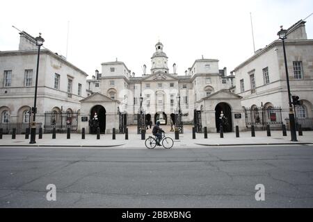 London, Großbritannien. April 2020. Tag Nine of Lockdown in London. Ein Radfahrer schaut auf Whitehall auf das Museum der Horse Guards, in dem es überhaupt keine Touristen gibt. Das Land befindet sich aufgrund der COVID-19-Coronavirus-Pandemie in der Sperrstelle. Die Menschen dürfen nicht nach Hause gehen, außer bei minimalem Lebensmitteleinkauf, medizinischer Behandlung, Bewegung - einmal am Tag und wesentlicher Arbeit. COVID-19 Coronavirus Lockdown, London, Großbritannien, am 1. April 2020 Credit: Paul Marriott/Alamy Live News Stockfoto