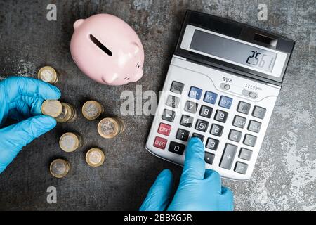 Buchhalter In Handschuhen Berechnet Geldbudget Der Piggybank Während Der Coronavirus Pandemie Stockfoto