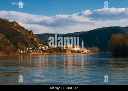 Foto eines kleinen Dorfes, das in der Nähe des Donau-Flusses in Österreich im Sonnenlicht gebadet wurde. Orte, die während der Reise nicht zu sehen sind. Stockfoto