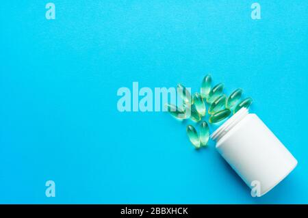 Kapseln, Kapseln für die Behandlung auf blauem Hintergrund. Gelbe Pillen mit Fischöl. Biologisch aktive Nahrungsergänzungsmittel. Flache Lage, Draufsicht. Stockfoto