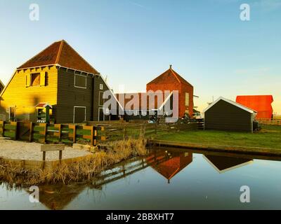 Bunte Holzhäuser, die bei Sonnenuntergang in holland an den holländischen Kanälen gebaut wurden Stockfoto