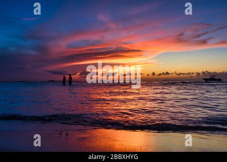 Junges Paar spazieren bei Ebbe auf einer tropischen Insel Holbox Mexiko. Unglaublicher Sonnenuntergang am Strand. Himmel mit unglaublichen Farben Sonne karibisches Meer Stockfoto