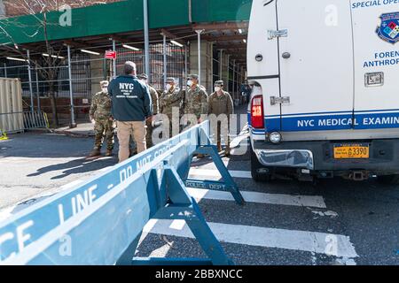 New York, USA. April 2020. Ein Mitarbeiter des Büros eines medizinischen Prüfers gibt einer Einheit von Mitgliedern der Nationalgarde in der East 3oth Street in der Nähe des Büros des Chefarztprüfers in New York City Anweisungen, während die Stadt sich auf einen Anstieg der COVID-19-Fälle vorbereitet, die eine medizinische Behandlung erfordern; April 2020 in New York, NY, USA statt. (Foto von Albin Lohr-Jones/Sipa USA) Credit: SIPA USA/Alamy Live News Stockfoto