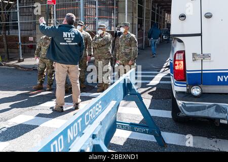 New York, USA. April 2020. Ein Mitarbeiter des Büros eines medizinischen Prüfers gibt einer Einheit von Mitgliedern der Nationalgarde in der East 3oth Street in der Nähe des Büros des Chefarztprüfers in New York City Anweisungen, während die Stadt sich auf einen Anstieg der COVID-19-Fälle vorbereitet, die eine medizinische Behandlung erfordern; April 2020 in New York, NY, USA statt. (Foto von Albin Lohr-Jones/Sipa USA) Credit: SIPA USA/Alamy Live News Stockfoto