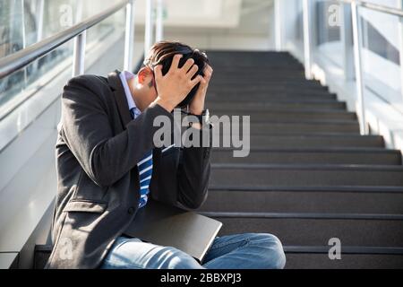 Geschäftsmann verlor in Depressionen weinend auf der Straßentreppe sitzend, und litt unter emotionaler Schmerztraurigkeit. Arbeitslose arbeitslose Menschen Krise, die Stress an Stockfoto