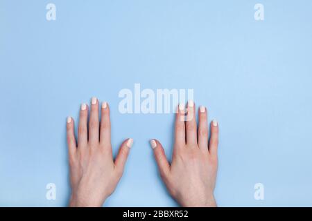 Auf dem Tisch liegen schöne weibliche Hände mit klassischer Mattenmaniküre. Platz für Ihren Text. Stockfoto