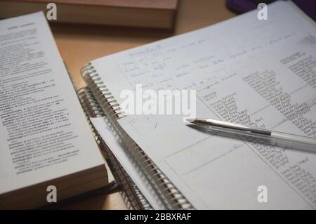 Einige Notizbücher, zusammen mit einem Spanisch-englischen Wörterbuch auf dem Tisch eines Englischstudenten Stockfoto