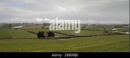 Blick auf die Landschaft von Rathfriland hinunter mit den Bergen von Mourne, die von einem lokalisierten Schneefall über höherem Boden aus im Schnee verblüfft wurden. Stockfoto