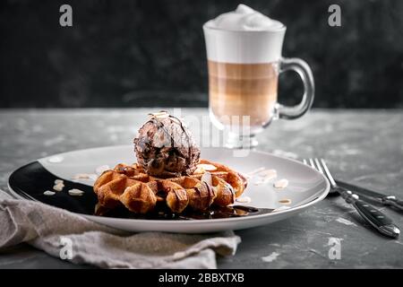 Wiener Waffeln mit Eis und Kaffee. Wunderschönes Dessertbild mit Lettenkaffee. Dessertkonzept, süßes Leben. Lebensmittelfoto, Kopierbereich, grau Stockfoto