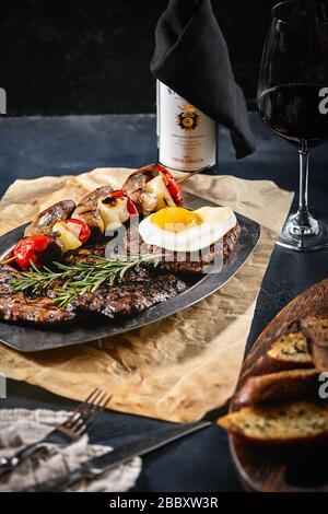 Grillplatte auf einem Teller mit gegrilltem Gemüse, gegrilltem Fleisch. Food Foto, dunkler Hintergrund Stockfoto