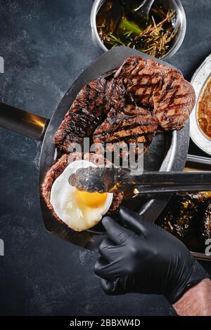 Grillplatte auf einem Teller mit gegrilltem Gemüse, gegrilltem Fleisch. Food Foto, dunkler Hintergrund Stockfoto