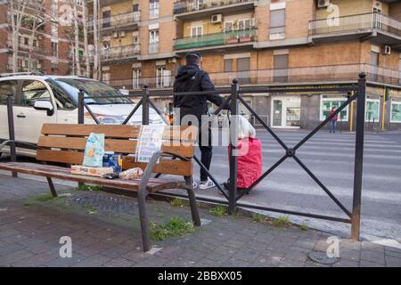 Roma, Italien. April 2020. In Rom, in der Via Oderisi da Gubbio, Bezirk Marconi, auf einer Bank am Ausgang eines Supermarktes, legen Leute Lebensmittel und verschiedene Lebensmittel, um Familien in Schwierigkeiten während der Covid-19-Pandemie zu helfen (Foto von Matteo Nardone/Pacific Press) Kredit: Pacific Press Agency/Alamy Live News Stockfoto