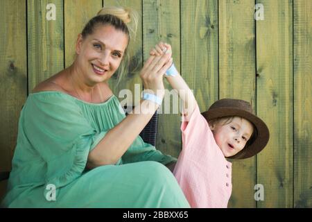Emotionen porträtieren Großmutter und seine Enkelin im ländlichen Stil auf grünem Holzhintergrund. Familienkonzept. Weicher Fokus. Stockfoto
