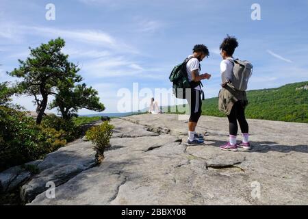 Junge Erwachsene, die im Minnewaska State Park Preserve, Mohonk Preserve, Gertüde's Nose, dem Grat, Felsformationen in den Shawangunks wandern. Hudson Valley Stockfoto