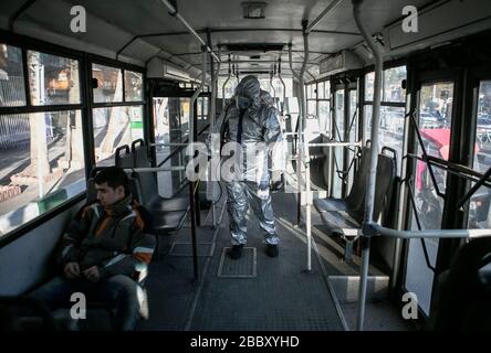 Teheran, Iran. März 2020. Ein Freiwilliger desinfiziert einen Bus in Teheran, Iran, 31. März 2020. Kredit: Ahmad Halabisaz/Xinhua/Alamy Live News Stockfoto