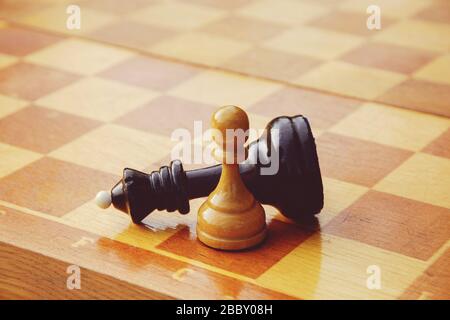 Spiel am Ende des Schachs - weiße Bauern gewinnen gegen den schwarzen König Stockfoto