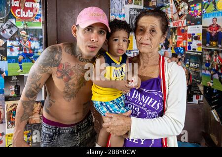 Junger tätowierte Friseur mit seiner Mutter und seinem jüngeren Bruder, Alt Havanna Stockfoto