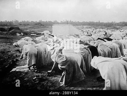 Arabische Männer, die in der Wüste beten, können. 1910-1915 Stockfoto