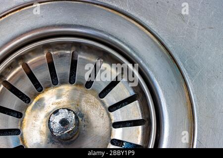 Ein Metallwaschbecken mit Ablaufloch, Makroansicht. Mechanisch verstellbare Ablassschraube in der Nähe. Stockfoto