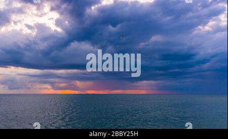 Dunkle dramatische stürmische cumulus-wolkenlandschaft über die Meereslandschaft des Ozeans bei Sonnenuntergang Licht. Majestätischer Himmel Dämmerung Hintergrund. Stockfoto