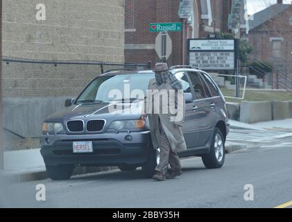 Worcester, Massachusetts, USA. April 2020. Ein Mann hat sein Gesicht mit einem Schal umhüllt, wie Präsident Trump vorschlug, anstatt während der Corona-Virus, Covid-19-Pandemie, geeignete medizinische Masken zu verwenden. In der Nähe des DCU-Zentrums wurde ein Notkrankenhaus eingerichtet, und Gouverneur Charles Baker hat dem Staat gerade einen Bericht über die aktuelle Virensituation gegeben. Kredit: Kenneth Martin/ZUMA Wire/Alamy Live News Stockfoto