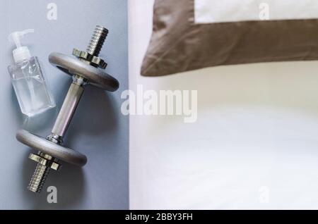 Flasche Alkoholgel zum Reinigen der Hand nach dem Gebrauch von Hanteln beim Sport im Schlafzimmer zum Schutz der Infizierten vor Korona zu Hause Stockfoto