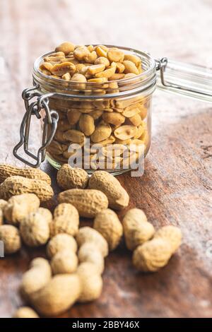 Geröstete gesalzene Erdnüsse. Knusprige Nüsse im Mixbecher auf Holztisch. Stockfoto