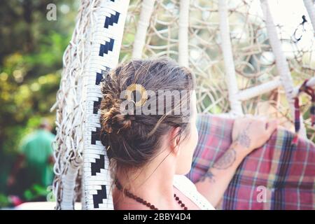 Elegante Frau in einem Schwingen, die einen Metallhaarstift in ihrem Haarbun trägt Stockfoto