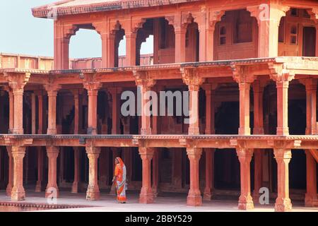 Frau, die in der Nähe von Diwan Khana-i-Khas im Fatehpur Sikri Complex, Uttar Pradesh, Indien, spazieren geht. Fatehpur Sikri ist eines der am besten erhaltenen Beispiele für Mughal Stockfoto