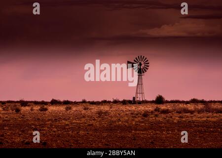 Silhouette einer Windmühle im Abendlicht auf einer Farm in der karoo Südafrika Stockfoto