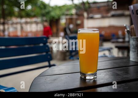Volles saftiges IPA-Bier aus Pint Glass auf Picknicktisch im Restaurant Stockfoto
