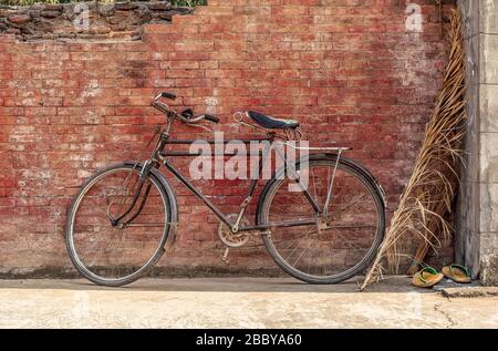 Retro-Stil klassisches Fahrrad vor roten alten Ziegelwänden geparkt Stockfoto