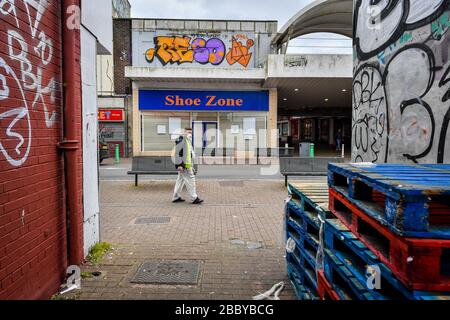 Ein Mann, der eine Gesichtsmaske trägt, passiert geschlossene Geschäfte in Bedminster, Bristol, während das Vereinigte Königreich weiterhin in Lockdown fährt, um die Ausbreitung des Coronavirus einzudämmen. Stockfoto