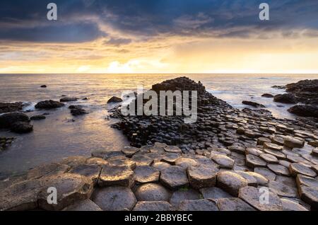 Ein epischer Sonnenuntergang am Giant's Causeway mit seinen kultigen Basaltsäulen. County Antrim, Ulster Region, Nordirland, Großbritannien. Stockfoto