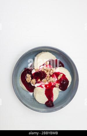 Käsekäse oder Pfannkuchen mit Kirschsoße und gehackten Nüssen auf weißem Hintergrund. Isoliert. Stockfoto