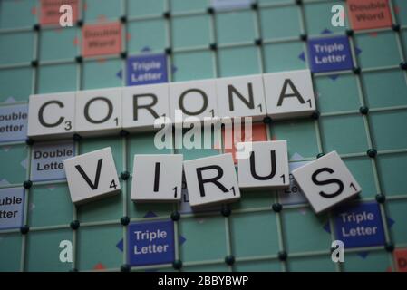 Coronavirus buchstabierte auf einem Scrabble Board. Konzeptbild für redaktionelle Kovid-19-bezogene Geschichten. Mit selektivem Fokus. Stockfoto