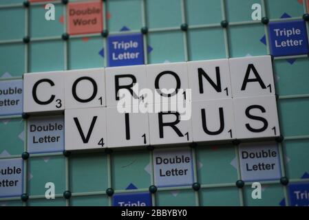 Coronavirus buchstabierte auf einem Scrabble Board. Konzeptbild für redaktionelle Kovid-19-bezogene Geschichten. Mit selektivem Fokus. Stockfoto