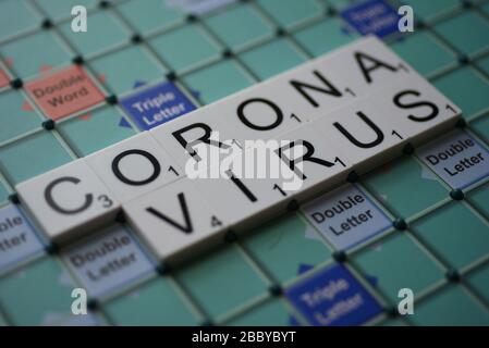 Coronavirus buchstabierte auf einem Scrabble Board. Konzeptbild für redaktionelle Kovid-19-bezogene Geschichten. Mit selektivem Fokus. Stockfoto