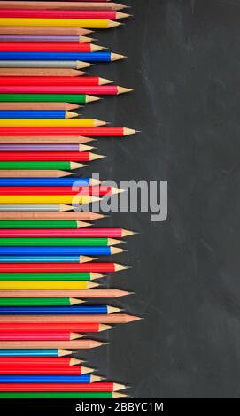 Schule, Bildungskonzept. Bunte Bleistifte umranden auf Tafel, Kopierraum, vertikal Stockfoto
