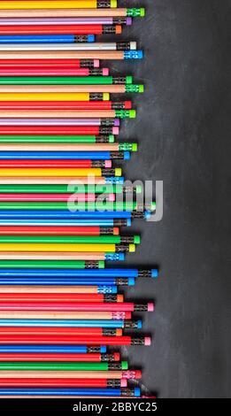 Schule, Bildungskonzept. Bunte Bleistifte mit Radierern auf Tafel, Kopierraum, vertikal Stockfoto