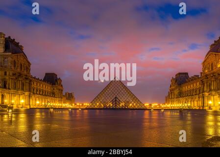 PARIS, FRANKREICH - 19. MÄRZ 2020: Blick auf den berühmten Louvre mit der Louvre Pyramide bei Sonnenaufgang. Das Louvre Museum ist eine der größten und meistbesuchten Museen Stockfoto