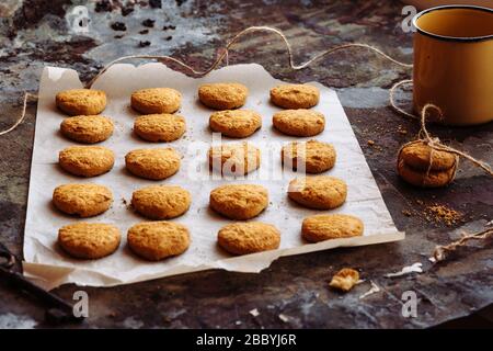Frisch gebackene herzförmige Plätzchen auf Pergamentpapier. Stockfoto