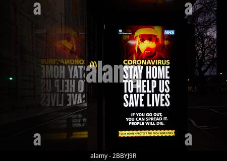 London, Großbritannien - 02. April 2020: Eine Nachricht der britischen Regierung über elektronische Plakate einer Bushaltestelle, die die Öffentlichkeit warnt, während der Coronavirus-Pandemie zu Hause zu bleiben. Stockfoto