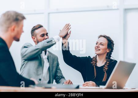 Junge Mitarbeiter geben einen hohen fünf Stockfoto