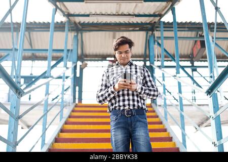 Junger Mann mit Handy beim Treppensteigen Stockfoto