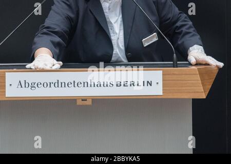 Berlin, Deutschland. April 2020. Das Rednerpult in der Abgeordnetenkammer wird während der Vollversammlung gereinigt. Kredit: Jörg Carstensen / dpa / Alamy Live News Stockfoto