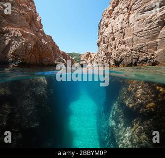 Boot in einer engen Passage an der felsigen Küste, geteilter Blick über und unter der Wasseroberfläche, Mittelmeer, Spanien, Costa Brava, Katalonien Stockfoto